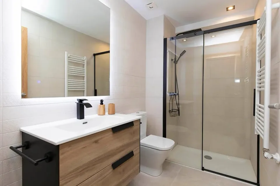 Bathroom with shower and large mirror. Light tones, a shower screen and vanity for everyday comfort during your stay.