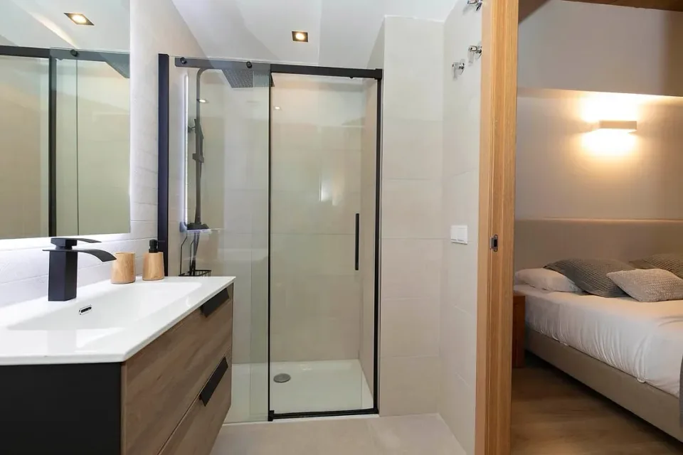 Bathroom beside the double bedroom. A screened shower and washbasin in a simple, light-toned space.