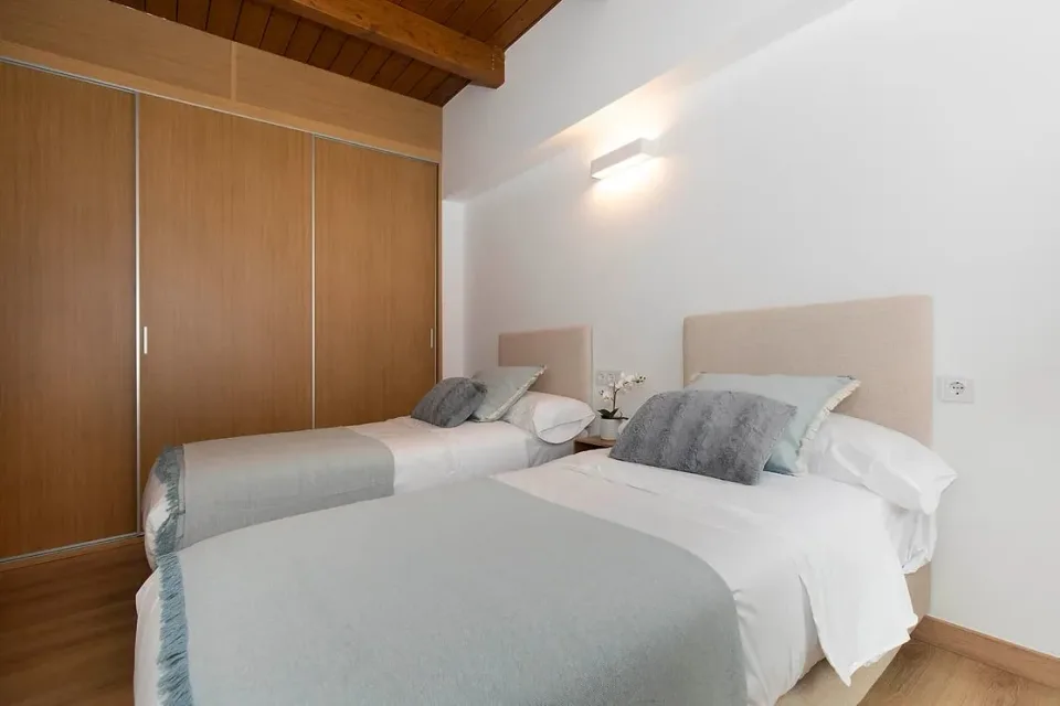 Twin beds and a wooden wardrobe. A bedroom with storage to unpack your bags and settle in.