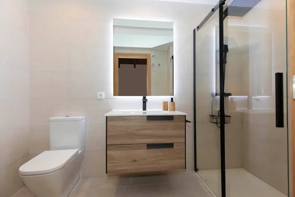 Bathroom with shower and wooden vanity. A practical, bright bathroom for getting ready to explore Panticosa.